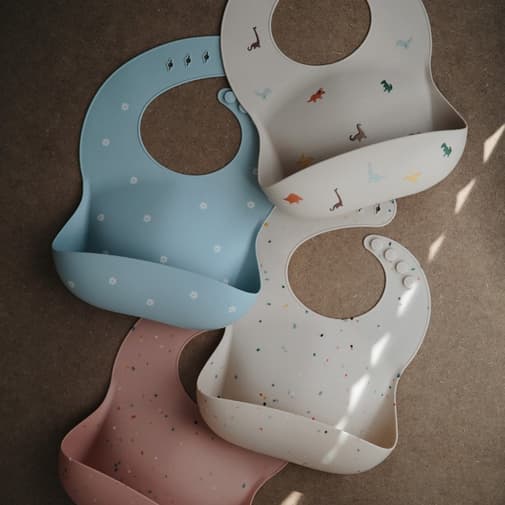 Mushie - Bavoir à poche en silicone Dinosaure